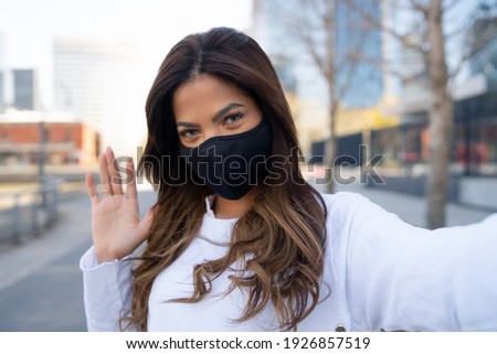 Young woman taking selfies outdoors.