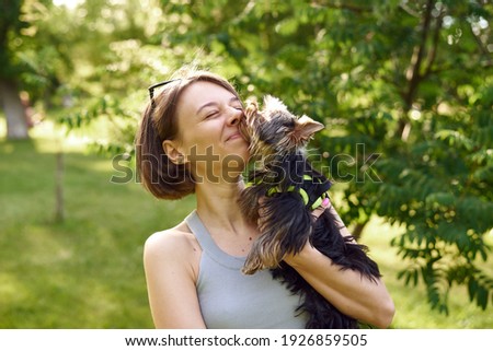 A small dog kisses on the nose and licks its master. Walking with your pet