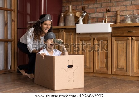 Overjoyed young Latino mother have fun engaged in funny activity with little 7s daughter. Excited Hispanic mom or nanny play pirates game with small girl child, feel playful on weekend at home. Royalty-Free Stock Photo #1926862907