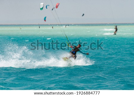 Kitesurfing on the waves of the Red sea, Egipt. Kitesurfing, Kiteboarding action photos Kitesurfer In action Royalty-Free Stock Photo #1926884777