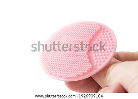 Cosmetic facial brush in hand on a white background, isolate. Copy space for text