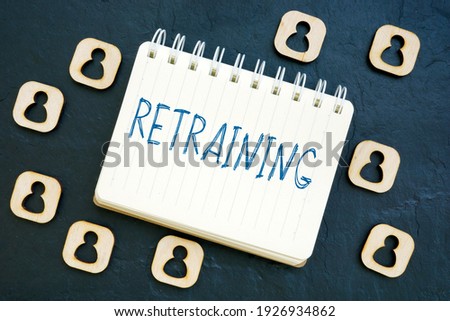 Retraining word on the notepad and small figurines. Royalty-Free Stock Photo #1926934862