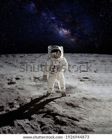 An astronaut walking on the surface of the moon with earth on lunar landing space mission. Elements of this image furnished by NASA.