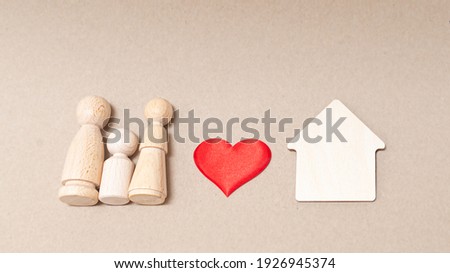 Figurines of a family made of wood with a heart and a house

