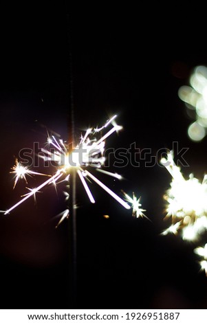 A lit sparkler on New Year's Eve in the dark. The beauty of flying sparks, Bengal fire