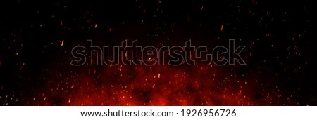 Fire embers particles over black background. Fire sparks background. Abstract dark glitter fire particles lights. bonfire in motion blur. Royalty-Free Stock Photo #1926956726