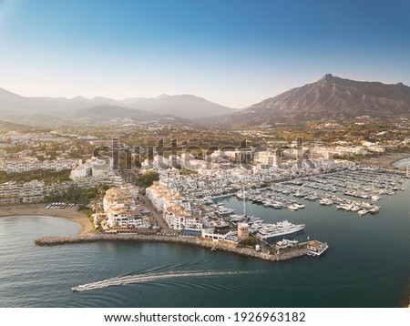 Aerial drone perspective of beautiful sunset over luxury Puerto Banus Bay in Marbella, Costa del Sol. Expensive lifestyle, luxury yachts. La concha mountain in background. Nueva Andalucía area