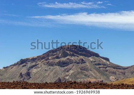 Mountain on Tenerife Island under a blue sky with desolated foreground and vegetation