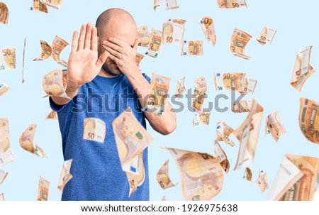 Young handsome man wearing casual t shirt covering eyes with hands and doing stop gesture with sad and fear expression. embarrassed and negative concept.