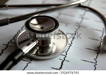 Stethoscope on top of an EKG recording. Royalty-Free Stock Photo #1926976745