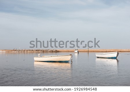 Dramatic photo of fishing boats in harbor in calm sunset light