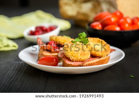 sandwich with fried camembert cheese, bacon and cranberries