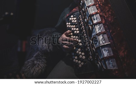 The musician plays the button accordion in the studio. The concept of music recording or music rehearsal.