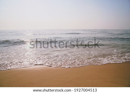 Cool light and mood of ripple wave, white bubbles, sand and sun rays reflect to sea water. Beach scene in morning. Calm and relax moment.