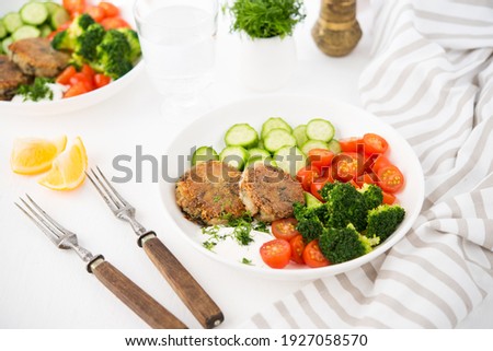 Vegetarian dish of potato patties with herbs and vegetables in a plate, selective focus