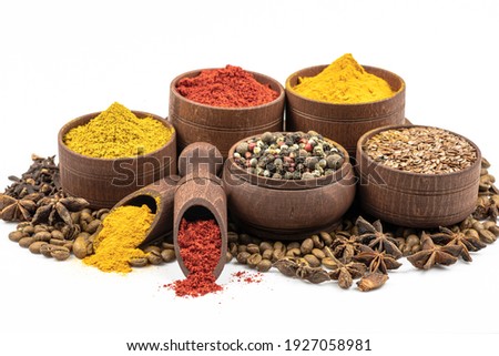 Assortment of east spices and seasonings in wooden tableware by close up isolated on a white background. Royalty-Free Stock Photo #1927058981