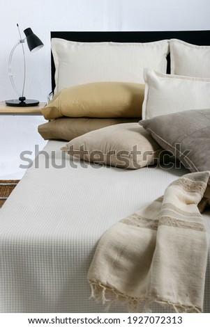 Home and bed products such as pillows, bedsheets, bedspreads, comforters, quilts and blankets,all in beige tones, in exhibition. Royalty-Free Stock Photo #1927072313