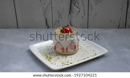 Strawberry magnolia in a glass mug on a blue and gray background