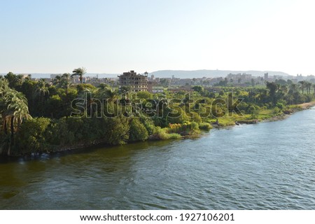 aerial view of Nile river with green nature and houses , palm and trees 