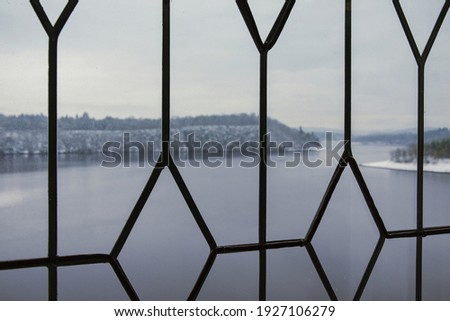 Vltava River view from the window with a patterned lattice. Orlik. Czech. December 2017