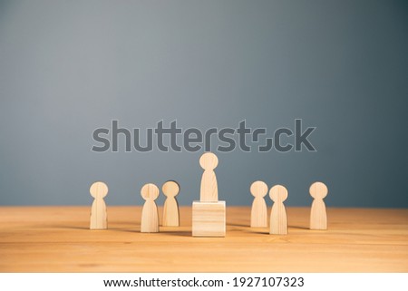 Teamwork and organization with wooden figures on wooden background



