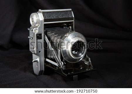Old vintage film camera on black background