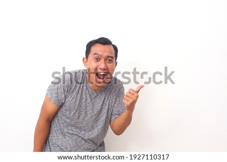 Portrait of asian man pointing something on empty space. Isolated on white with copyspace