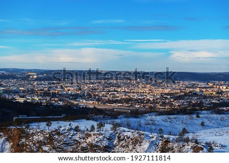 Winter view of the city of Brno in the Czech Republic in Europe. Houses and chimneys are visible. Palava can be seen in the background. There are dramatic clouds in the sky. Photo from Hady quarry.