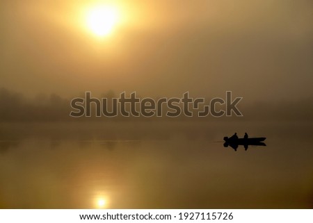 Morning. river, silhouette of a boat and fishermen, beautiful sunlight, reflection in the water of trees and the sun, a married couple in a boat, morning fishing, trolling, selective focus