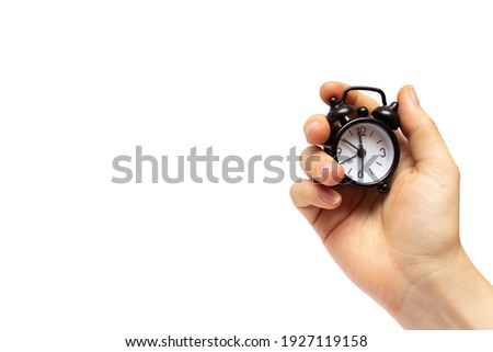 Creative idea about time. Black alarm clock in a female hand Royalty-Free Stock Photo #1927119158