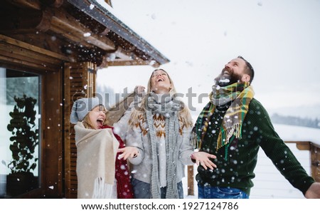 Family with small daughter having fun on terrace outdoors, holiday in winter nature.