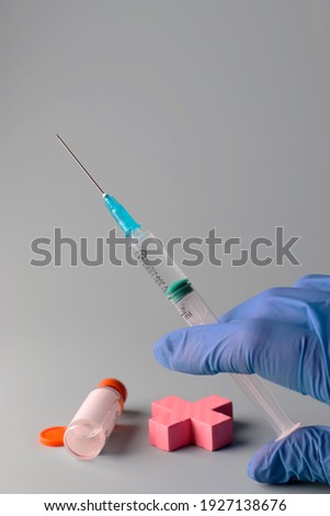 Concept of vaccine COVID19, nCoV 2019. Hands of a doctor in medical gloves hold a syringe filled with vaccine. Prevention, immunization and treatment for coronavirus infection. Vertical position.