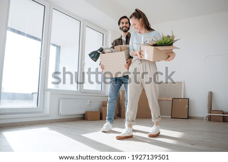 Young couple with boxes moving in new flat, new home and relocation concept. Royalty-Free Stock Photo #1927139501