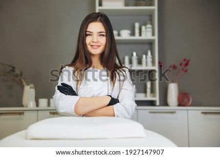Consultation in cosmetology clinic. Female beauty doctor in white coat and black gloves crossed hands. Healthcare concept. Royalty-Free Stock Photo #1927147907