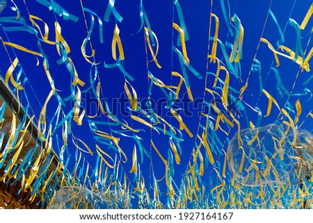 Multicolored ribbons against the blue sky. Festive decoration of the city streets for the spring holidays. happy Easter.