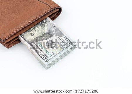 Brown leather wallet with dollars isolated on white background. Flat lay. Close up photo. Cash of hundred dollar bills