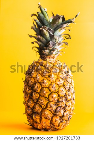 Pineapple on vibrant yellow surface in design and graphic art inspired composition.
