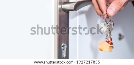 hands with keys on the door of house or apartment