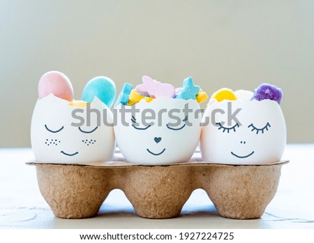 Cute Easter eggs with funny faces full of sweet candies. Easter and spring celebration concept