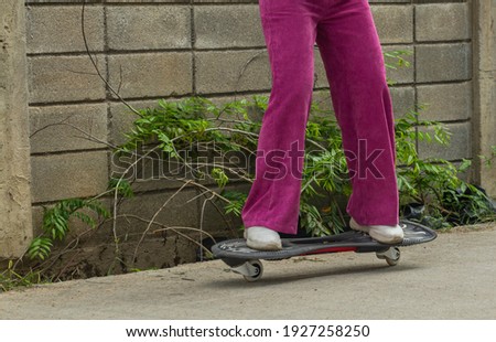 Closeup Asian woman in pink playing or skate board or surfskate in skate Park, extream sport, healthy and exercise, fashion in covid19 concept, sport concepts.