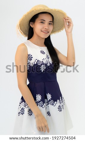 Smiling Asian woman wearing straw hat takes photos in studio white background. Concept take photo picture by camera in studio