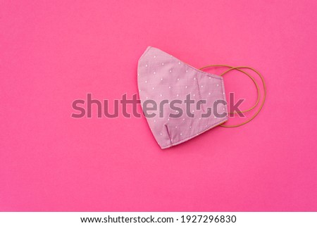 Mouth cover, multi-layer fabric, pink with yellow laces on minimalist solid pink background, special photo for social networks Royalty-Free Stock Photo #1927296830