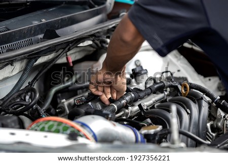 Hands of auto mechanic repairing car engine in garage. Maintenance car. Royalty-Free Stock Photo #1927356221