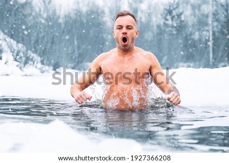 Man jumping in cold water in winter Royalty-Free Stock Photo #1927366208