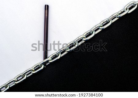 an iron chain divides the plane in half into black and white parts on the white part lies a fountain pen the concept of freedom of speech. High quality photo
