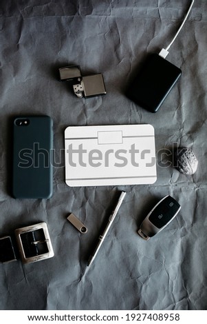 Men's accessories background, car keys, lighter, smartphone, pen, belt.