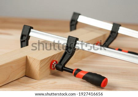 Iron clamps. Clamps and vices. Wooden bars on workshop table Royalty-Free Stock Photo #1927416656