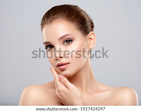 Closeup portrait of a  face of the young pretty girl with a healthy skin. Beautiful face of young white woman with a clean skin. Skin care concept.  Royalty-Free Stock Photo #1927424297
