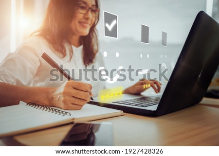 Businesswoman pressing face emoticon on the keyboard laptop .Customer service evaluation concept.	 Royalty-Free Stock Photo #1927428326