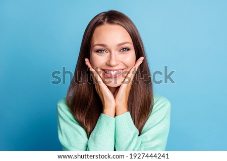 Photo portrait of adorable girl touching face cheeks with hands isolated on pastel blue colored background